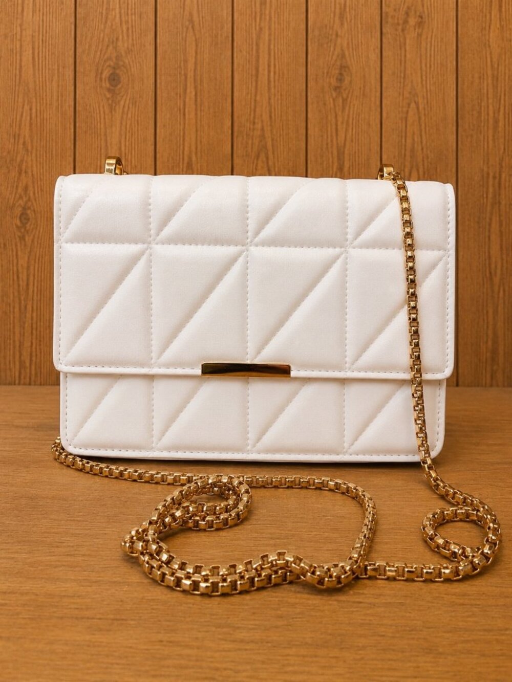 White quilted flap handbag featuring a geometric stitched design